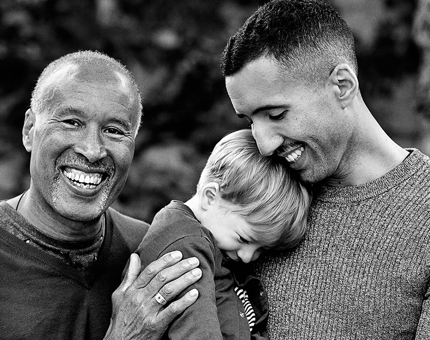 Two men with child, smiling to camera, after making a philanthropic donation to Movember.